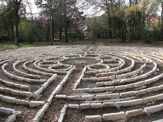 a labyrinth laid out in a flat backyard, walkway outlined with white rectangular stones 