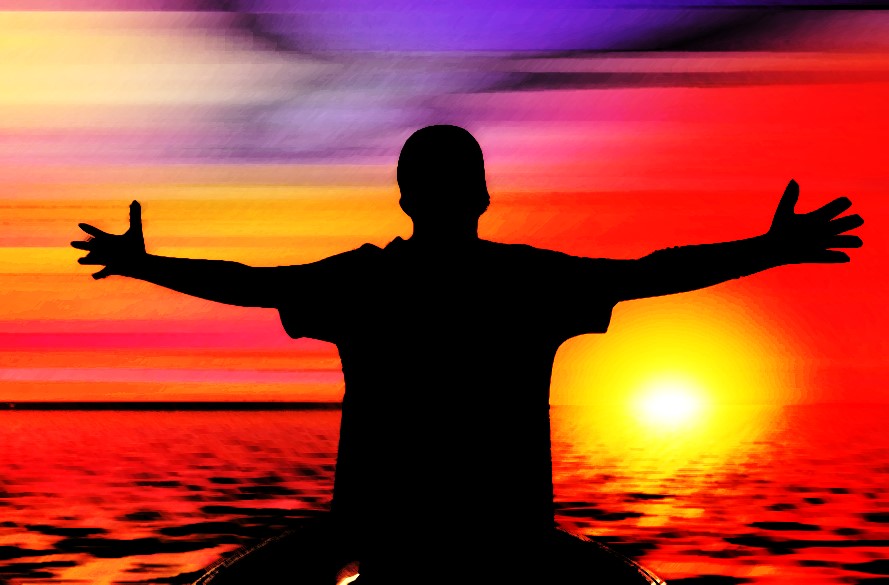 person standing waist-deep in water, facing away from viewer, arms outstretched to the rising sun