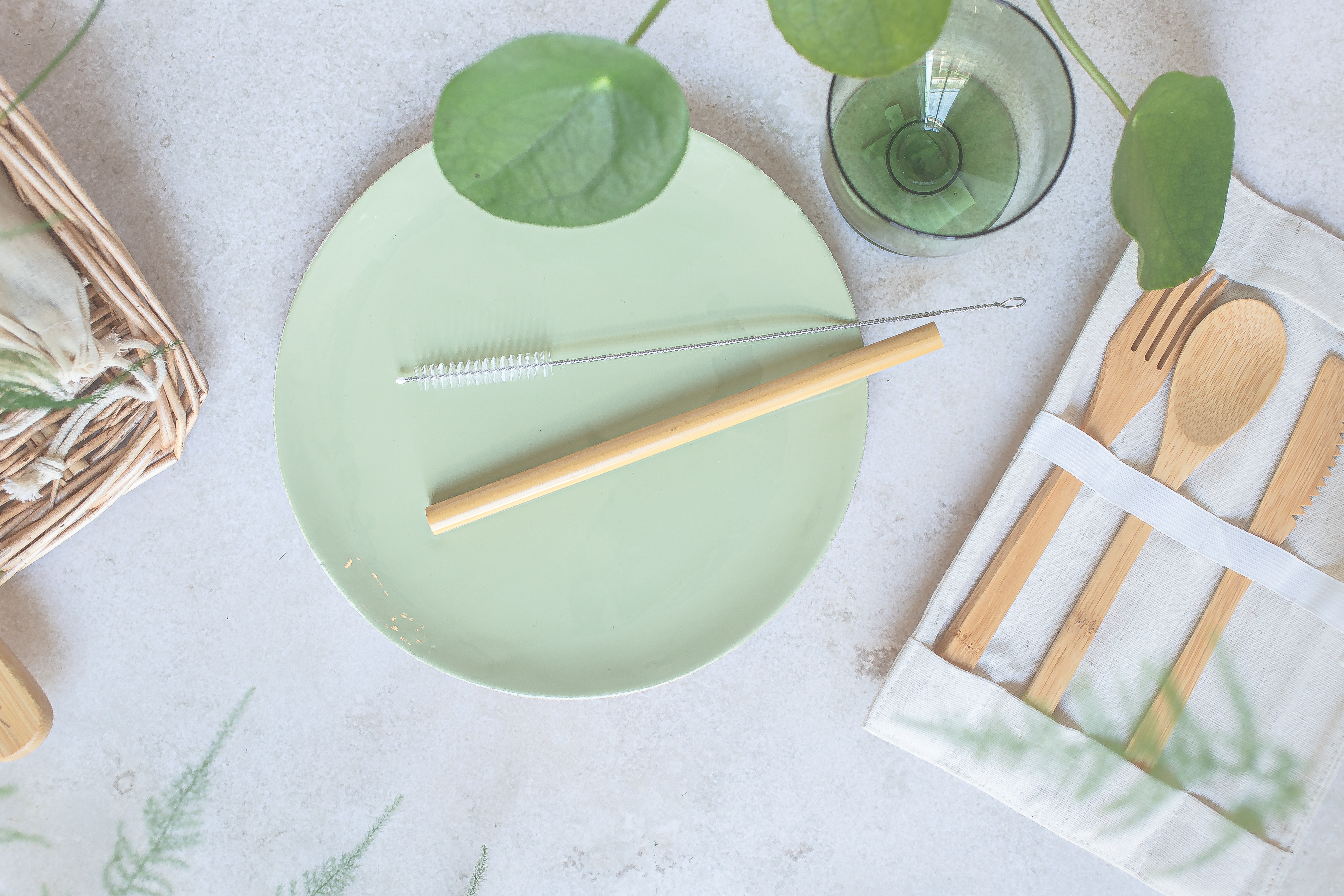 bamboo eating utensiles, straw, straw cleaner, and light green ceremic plate, drinking glass
